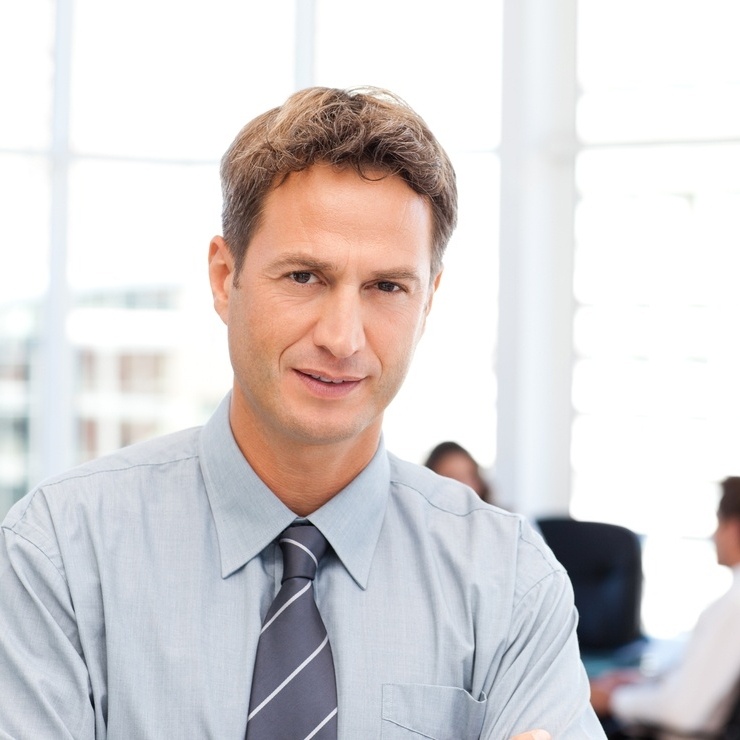 Severe businessman standing in front of his team while working at a table in the background-717308-edited.jpeg